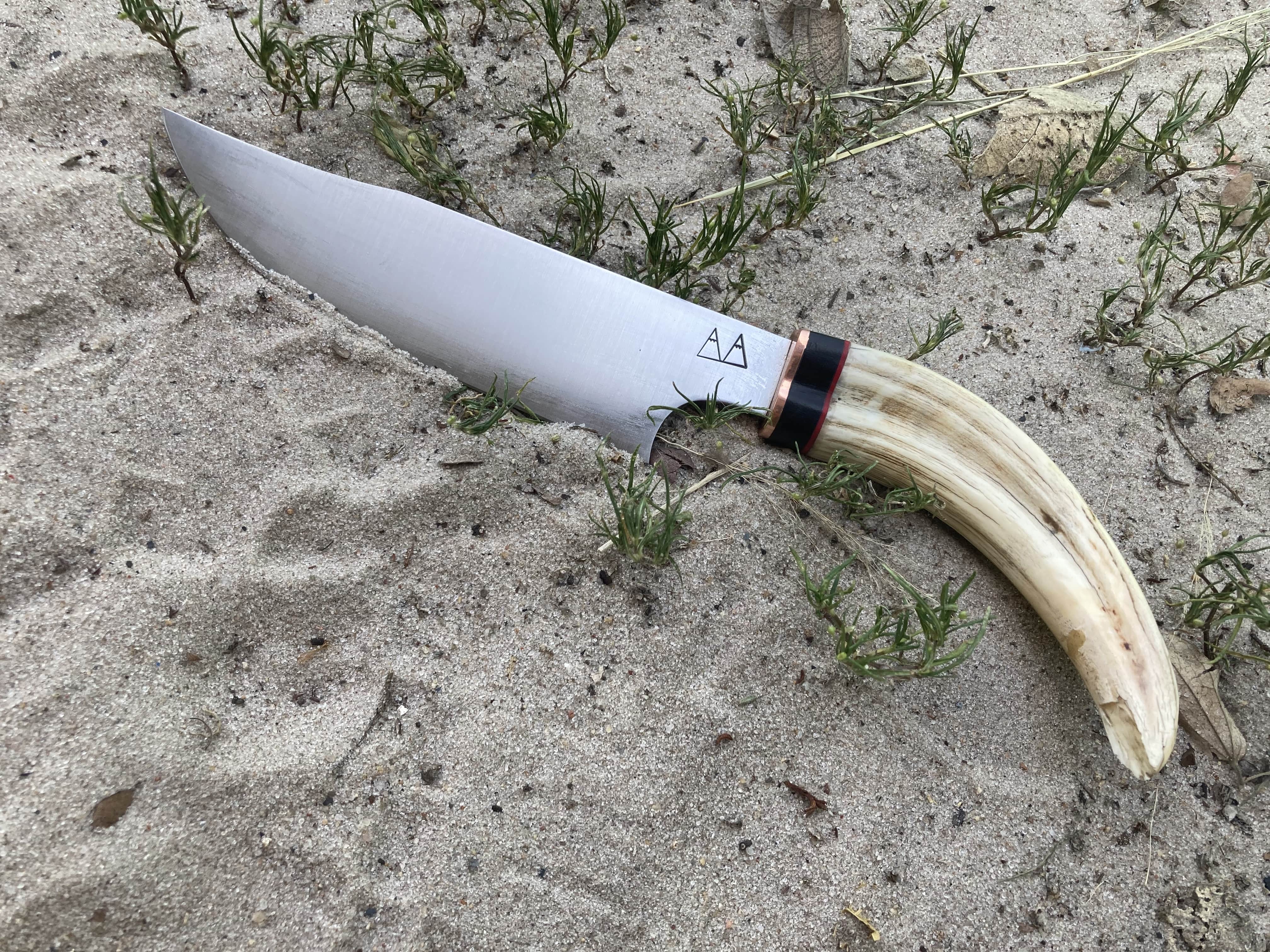 A camp chopper with a Warthog tusk handle and a copper and ebony bolster. A camp chopper with a Warthog tusk handle and a copper and ebony bolster.