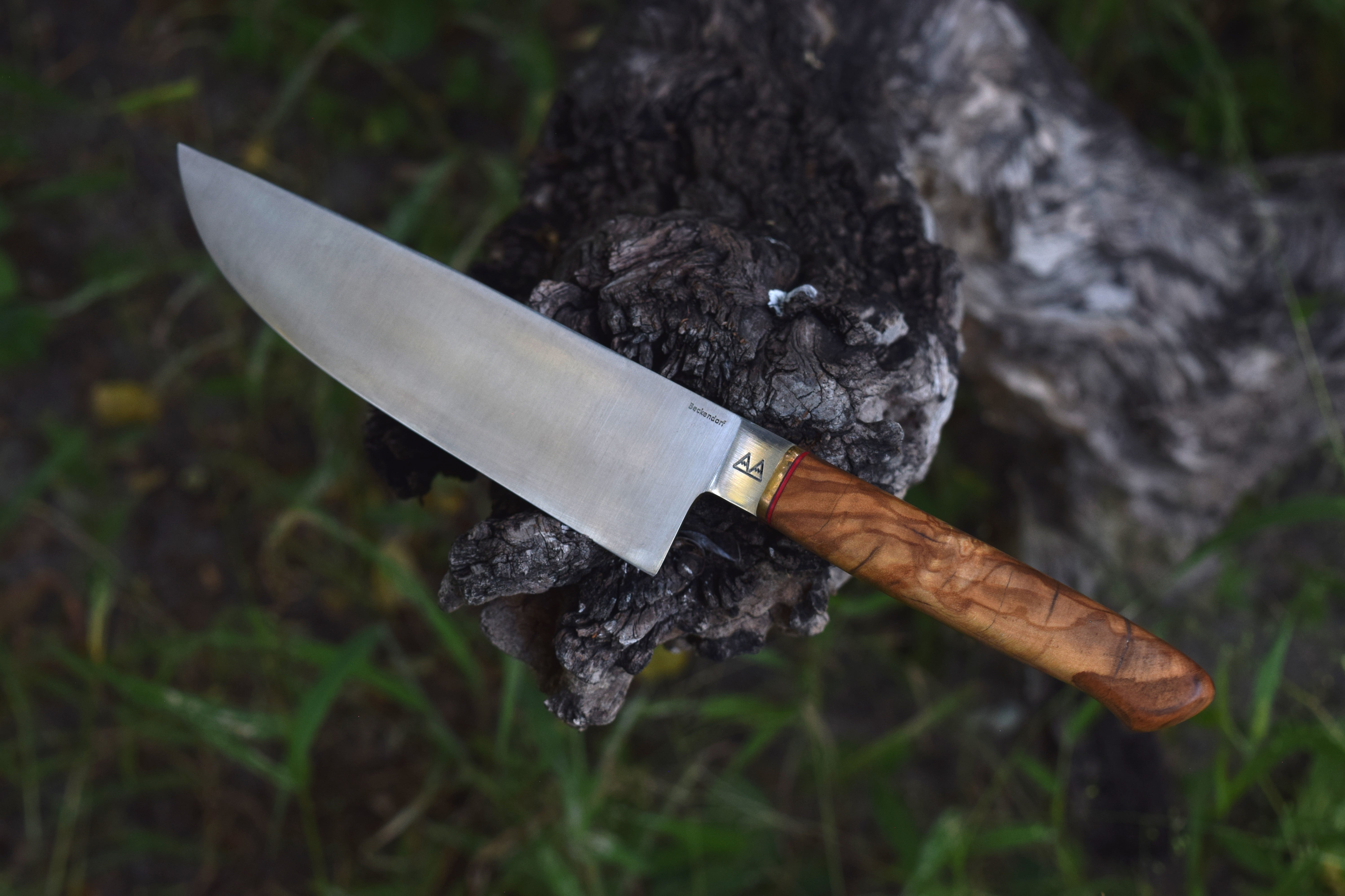 A chef's knife with an Olivewood handle. A chef's knife with an Olivewood handle.