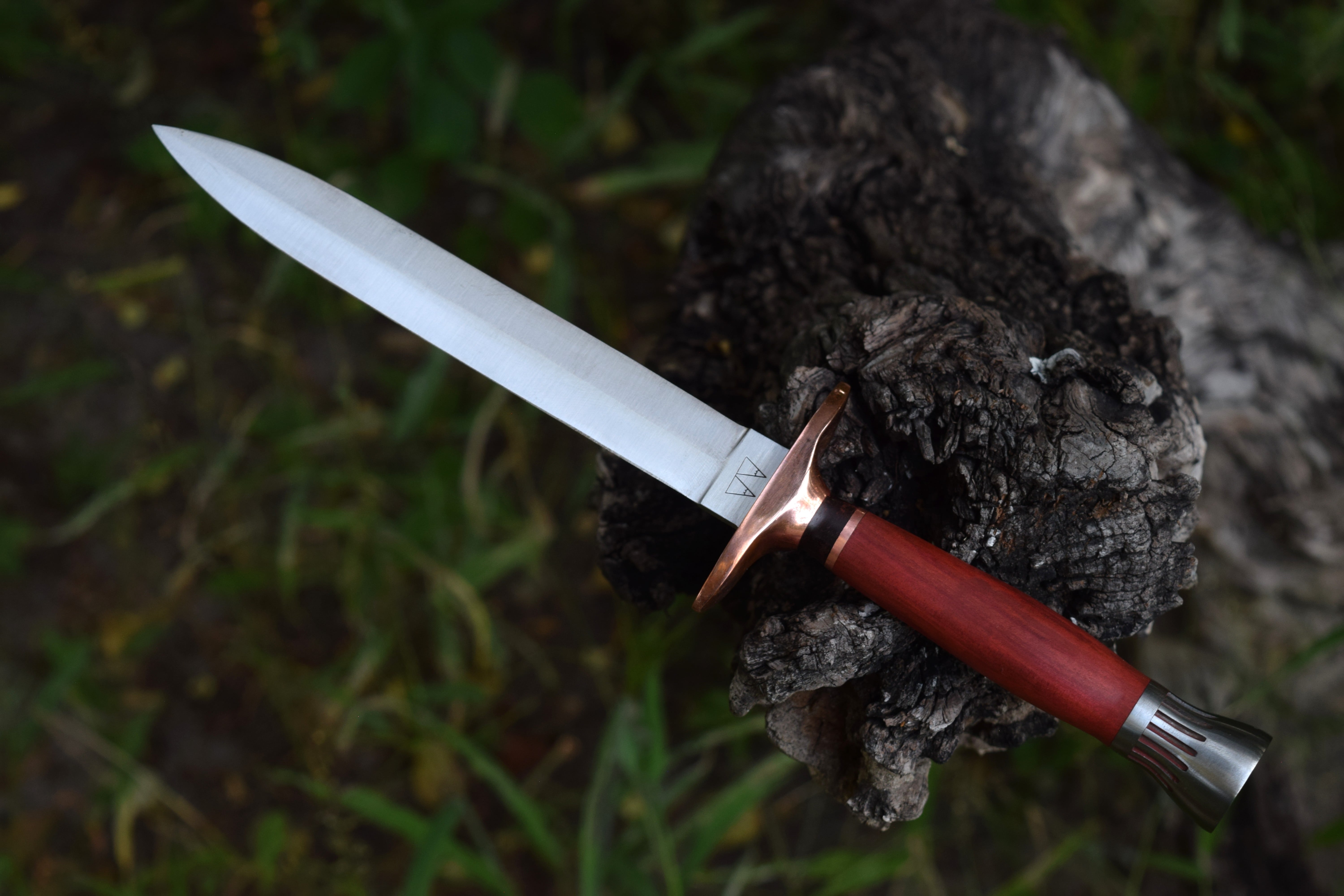 A dagger with a copper guard, Red Heart handle, and steel pommel. A dagger with a copper guard, Red Heart handle, and steel pommel.